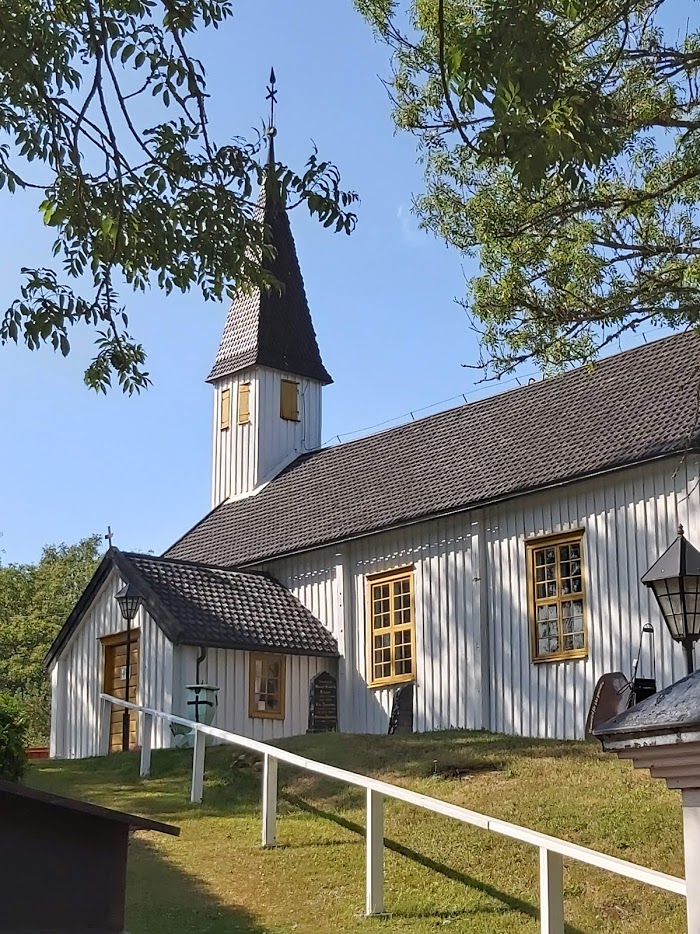 Lumparlands kyrka ligger på en liten gräskulle. Kyrkan är vitmålad trä.